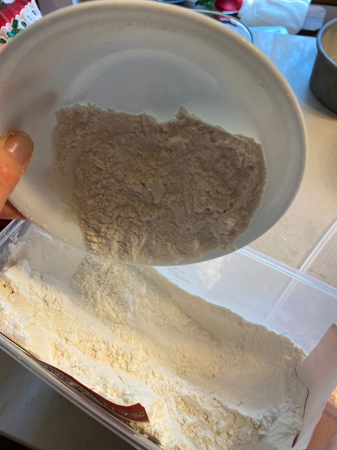 Mama pouring the excess back into the flour container